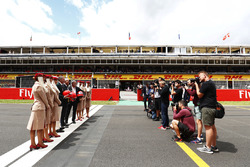 Sean Bratches, Managing Director of Commercial Operations, Formula One Group, Thierry Antinori, Executive Vice President and Chief Commercial Officer, Emirates Airlines, and Chase Carey, Chairman, Formula One, stand opposite photographers with flight attendants