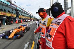 Marshals watch Fernando Alonso, McLaren MCL33 in pit lane