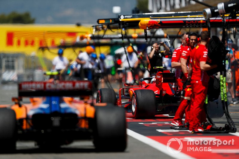 Lando Norris, McLaren MCL34, y Charles Leclerc, Ferrari SF90 en pit lane