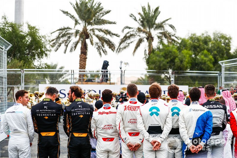 The drivers line up on the grid for the national anthem