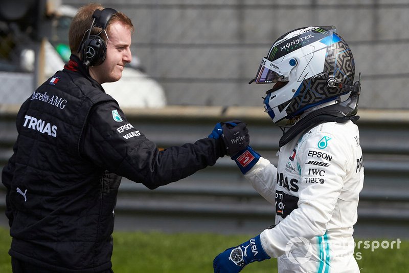 Valtteri Bottas, Mercedes AMG F1, is congratulated by a mechanic after securing pole position