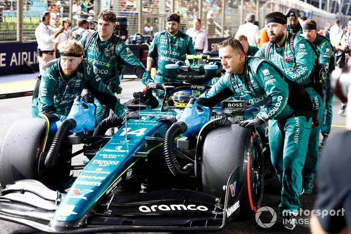 Los mecánicos llevan a Fernando Alonso, Aston Martin AMR23, a la parrilla de salida