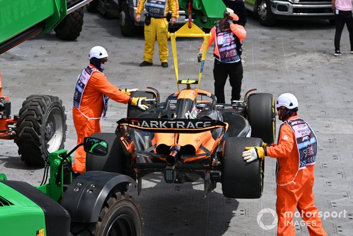 Los comisarios retiran el coche de Lando Norris, McLaren MCL38, después de que hiciera un trompo en la primera vuelta