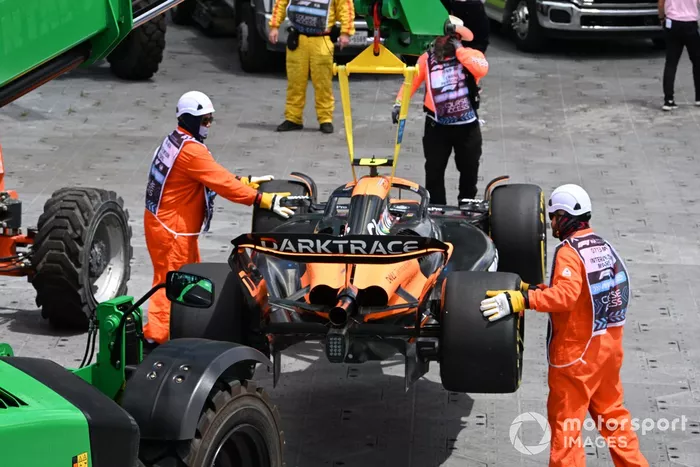 Los comisarios retiran el coche de Lando Norris, McLaren MCL38, después de que hiciera un trompo en la primera vuelta