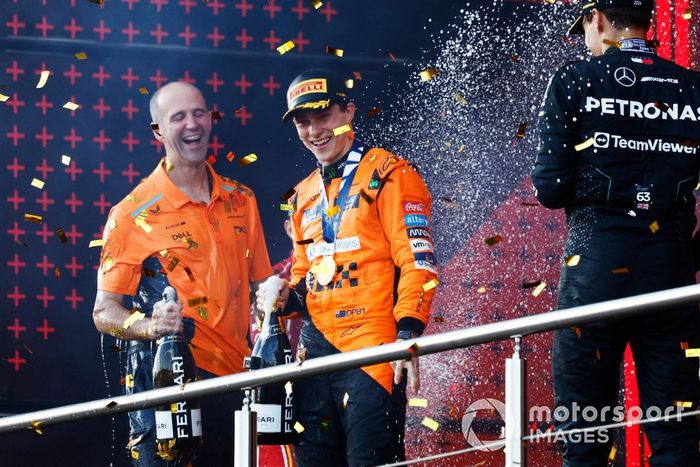 Oscar Piastri, McLaren F1 Team, 1ª posición, celebra con su compañero de equipo en el podio mientras cae confeti.