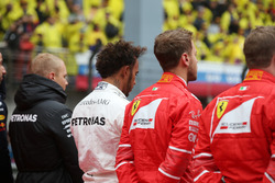 Valtteri Bottas, Mercedes AMG, Lewis Hamilton, Mercedes AMG, Sebastian Vettel, Ferrari, et Kimi Raikkonen, Ferrari, rejoignent les autres pilotes sur la grille pour l'hymne national