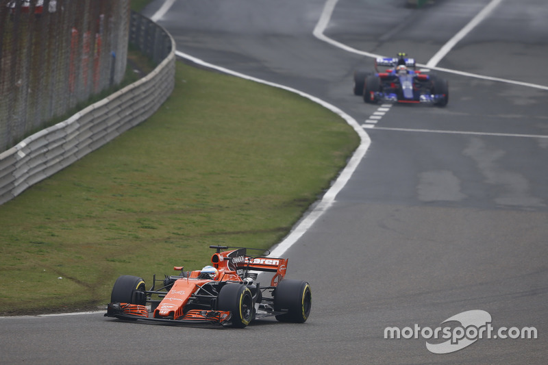 Fernando Alonso, McLaren MCL32, leads Carlos Sainz Jr., Scuderia Toro Rosso STR12, out of the pits