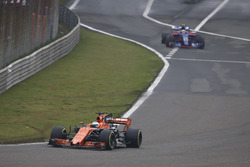 Fernando Alonso, McLaren MCL32, leads Carlos Sainz Jr., Scuderia Toro Rosso STR12, out of the pits