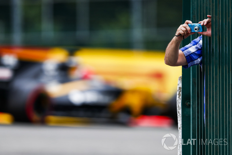 Un fan si sporge dalla barriera per scattare una foto mentre Nico Hulkenberg, Renault Sport F1 Team RS17, passa sullo sfondo