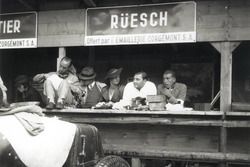 Zusammen mit Freunden verbringt Hans Rüesch 1934 eine Trainingspause in den Boxen von Bern. Vor ihm steht der Maserati 4CS, an dessen Steuer er das Rennen der