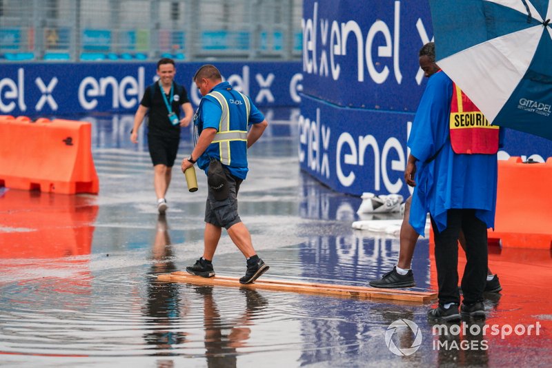 Oficial de pista camina por la pista mojada