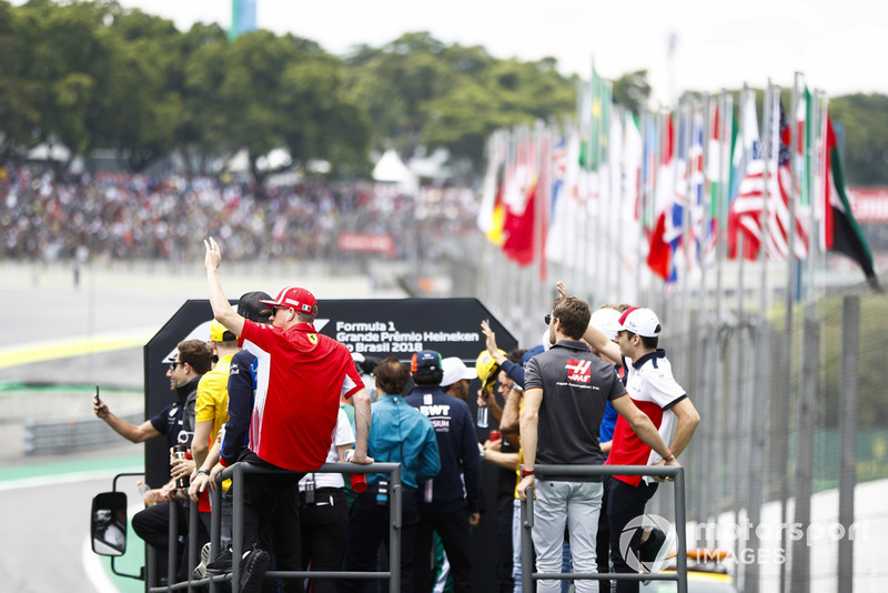 Kimi Raikkonen, Ferrari, waves to fans on the drivers' parade. Also present are Romain Grosjean, Haas F1 Team, Charles Leclerc, Sauber, Sergio Perez, Force India, Stoffel Vandoorne, McLaren, and Daniel Ricciardo, Red Bull Racing.
