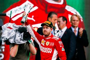 Sebastian Vettel, Ferrari, 2° classificato, alza il suo trofeo sul podio