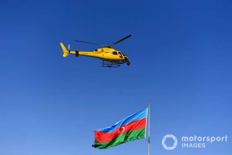 Un helicóptero Airbus Helicopters AS355 Ecureuil con una cámara sobre una bandera de Azerbaiyán