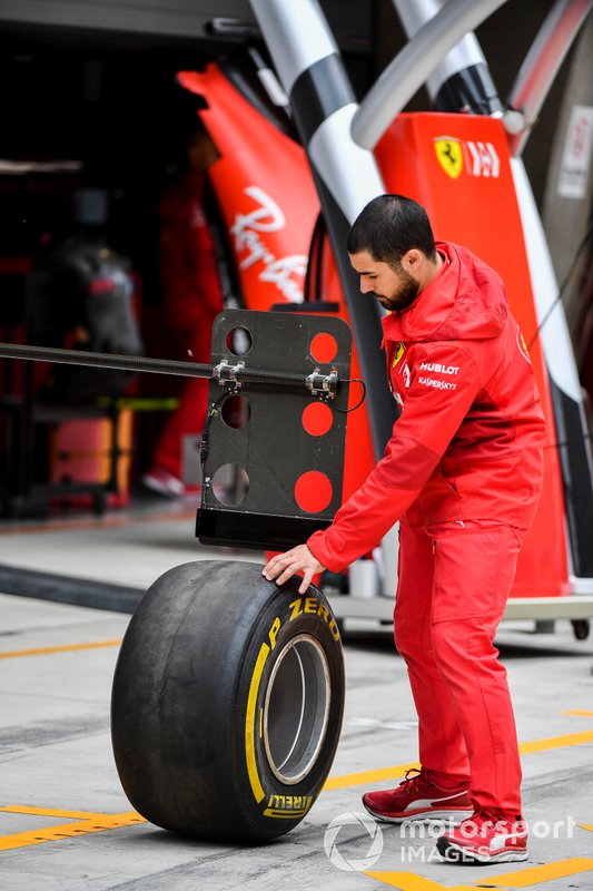Meccanico Ferrari in pit lane con una gomma Pirelli