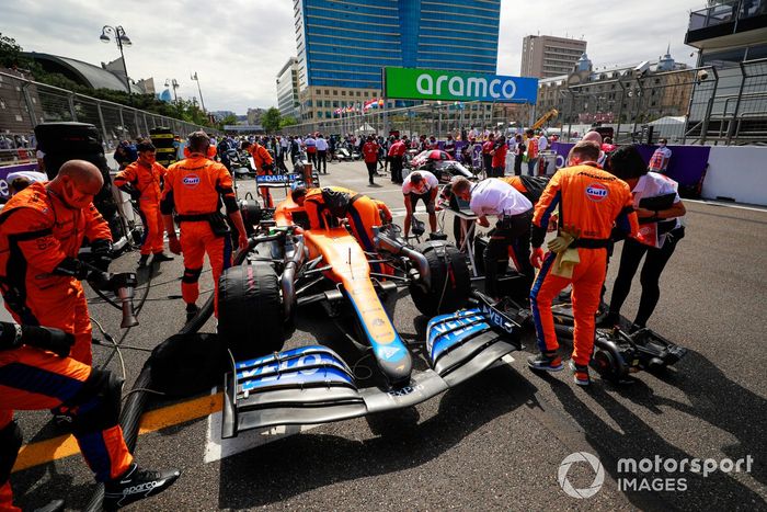 Mecánicos en la parrilla con el coche de Daniel Ricciardo, McLaren MCL35M
