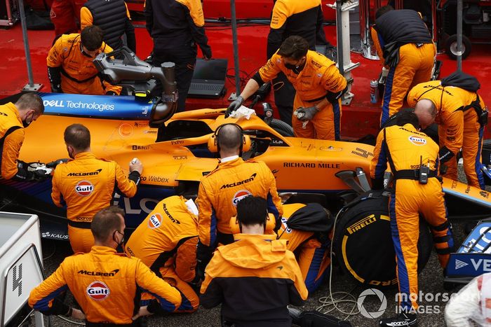 Los mecánicos trabajan en el coche de Lando Norris, McLaren MCL35M
