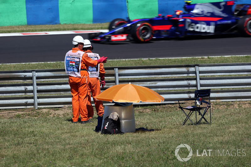 Oficiales observan a Carlos Sainz Jr., Scuderia Toro Rosso STR12