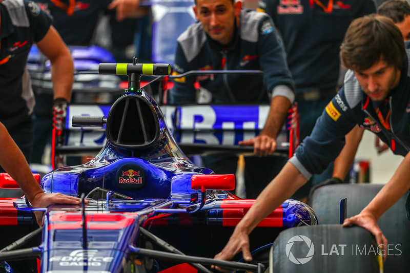El coche de Carlos Sainz Jr., Scuderia Toro Rosso STR12 es empujado por la mecánica