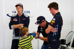 Max Verstappen, Red Bull Racing, signs an autograph for a young fan, as Brendon Hartley, Scuderia To