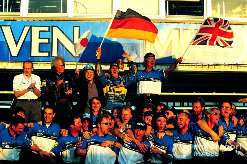 Michael Schumacher celebrates with Flavio Briatore, Luciano Benetton and rest of the Benetton Renault team after winning the World Drivers Championship and the Constructors Championship