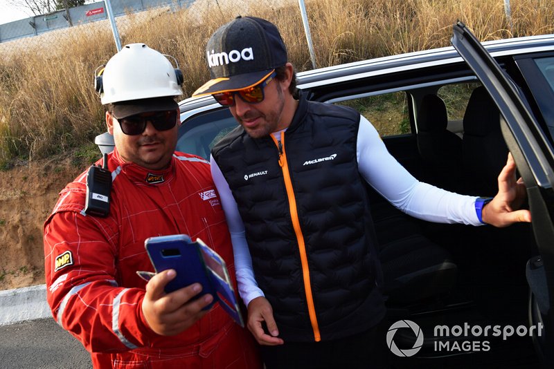 Fernando Alonso watches the action trackside