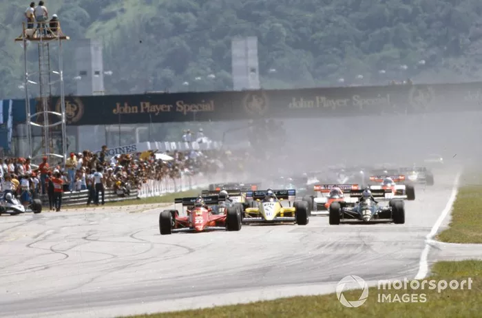 Michele Alboreto, Ferrari 126C4, lidera a Nigel Mansell, Lotus 95T Renault, y Derek Warwick, Renault RE50, en la salida