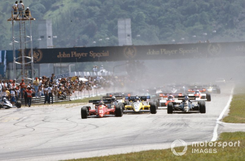 Michele Alboreto, Ferrari 126C4, lidera a Nigel Mansell, Lotus 95T Renault, y Derek Warwick, Renault RE50, en la salida