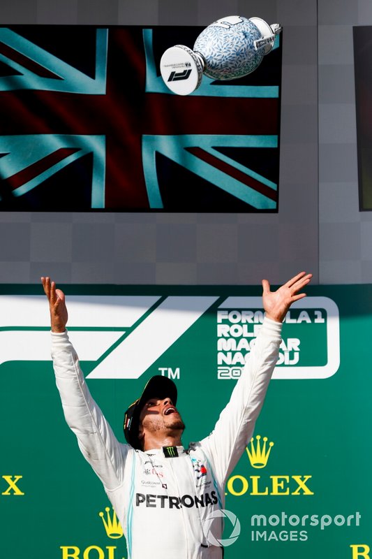 Lewis Hamilton, Mercedes AMG F1, 1st position, throws his trophy in the air in celebration on the podium