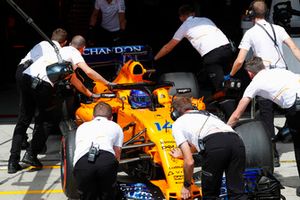 Mechanics return Fernando Alonso, McLaren MCL33, to the garage