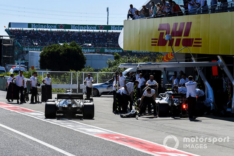 Valtteri Bottas, Mercedes AMG W10, and Lewis Hamilton, Mercedes AMG F1 W10, in the pit lane