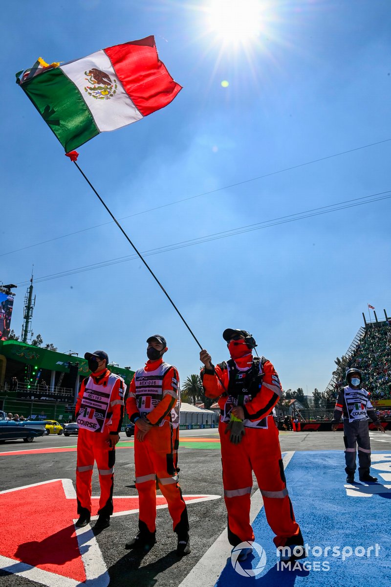 Oficiales de pista con bandera de México