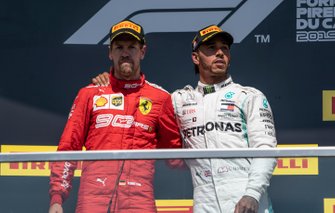 Sebastian Vettel, Ferrari, 2e plaats, en Lewis Hamilton, Mercedes AMG F1, 1e plaats, op het podium