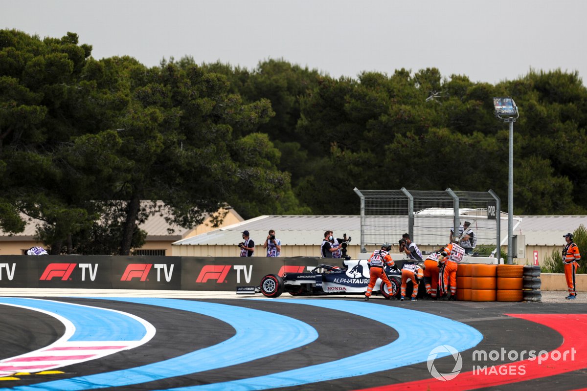 Los oficiales de pista asisten a Yuki Tsunoda, AlphaTauri AT02, después de chocar
