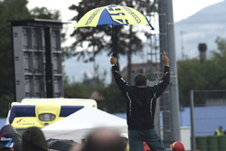 Een Rossi-fan staat op een bandenstapel te vieren dat Jorge Lorenzo ten val gekomen is.
