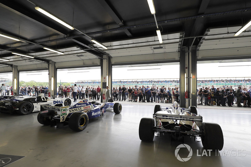 Fans view a garage filled with classic Williams F1 machinery
