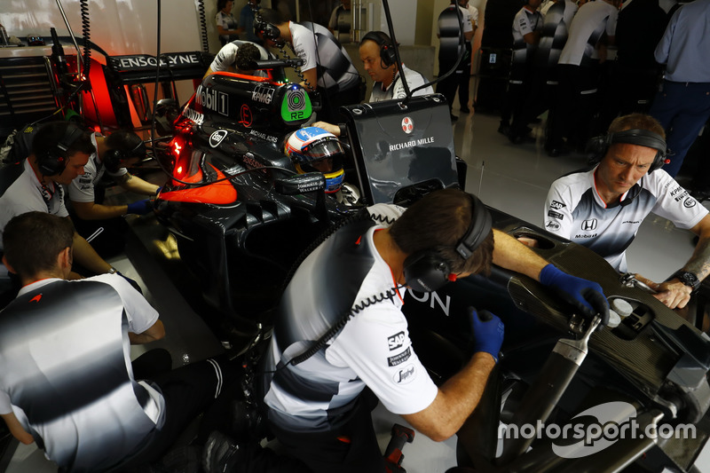 McLaren personnel work on Fernando Alonso's MP4-31 Honda in the garage