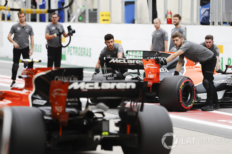 Engineers return Fernando Alonso, McLaren MCL32, to the garage