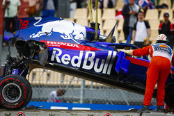 Marshals remove the damaged car of Brendon Hartley, Toro Rosso STR13, from the circuit as the gearbox hangs off the back