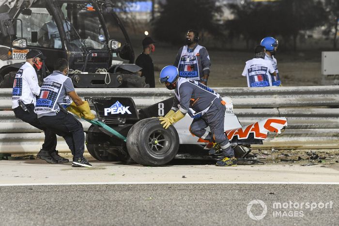 Los oficiales retiran los restos del monoplaza de Romain Grosjean, Haas VF-20, después del accidente en la primera vuelta