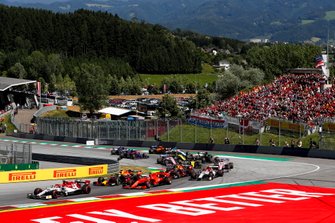 Kimi Raikkonen, Alfa Romeo Racing C38, voor Sebastian Vettel, Ferrari SF90, Max Verstappen, Red Bull Racing RB15, Pierre Gasly, Red Bull Racing RB15, Antonio Giovinazzi, Alfa Romeo Racing C38, and the remainder of the field at the start