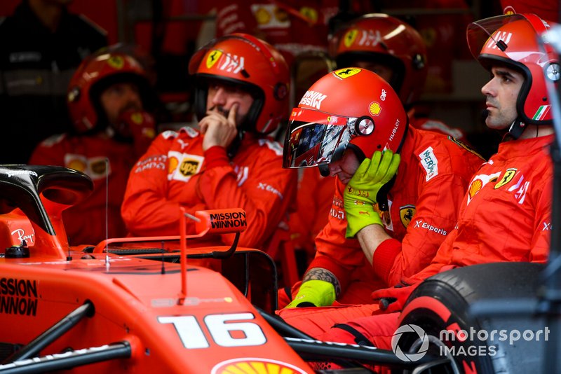 El mecánico se sentó en el garaje junto al coche retirado de Charles Leclerc, Ferrari SF90.