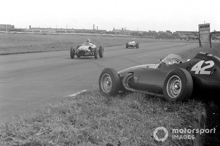 Roy Salvadori, Aston Martin DBR4/250, delante de Chris Bristow, Cooper T51 Borgward, pasan por el BRM P25 de Ron Flockhart que quedó fuera de la competencia.