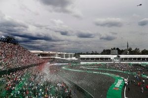 Los aficionados invaden la pista en el podio después de la carrera