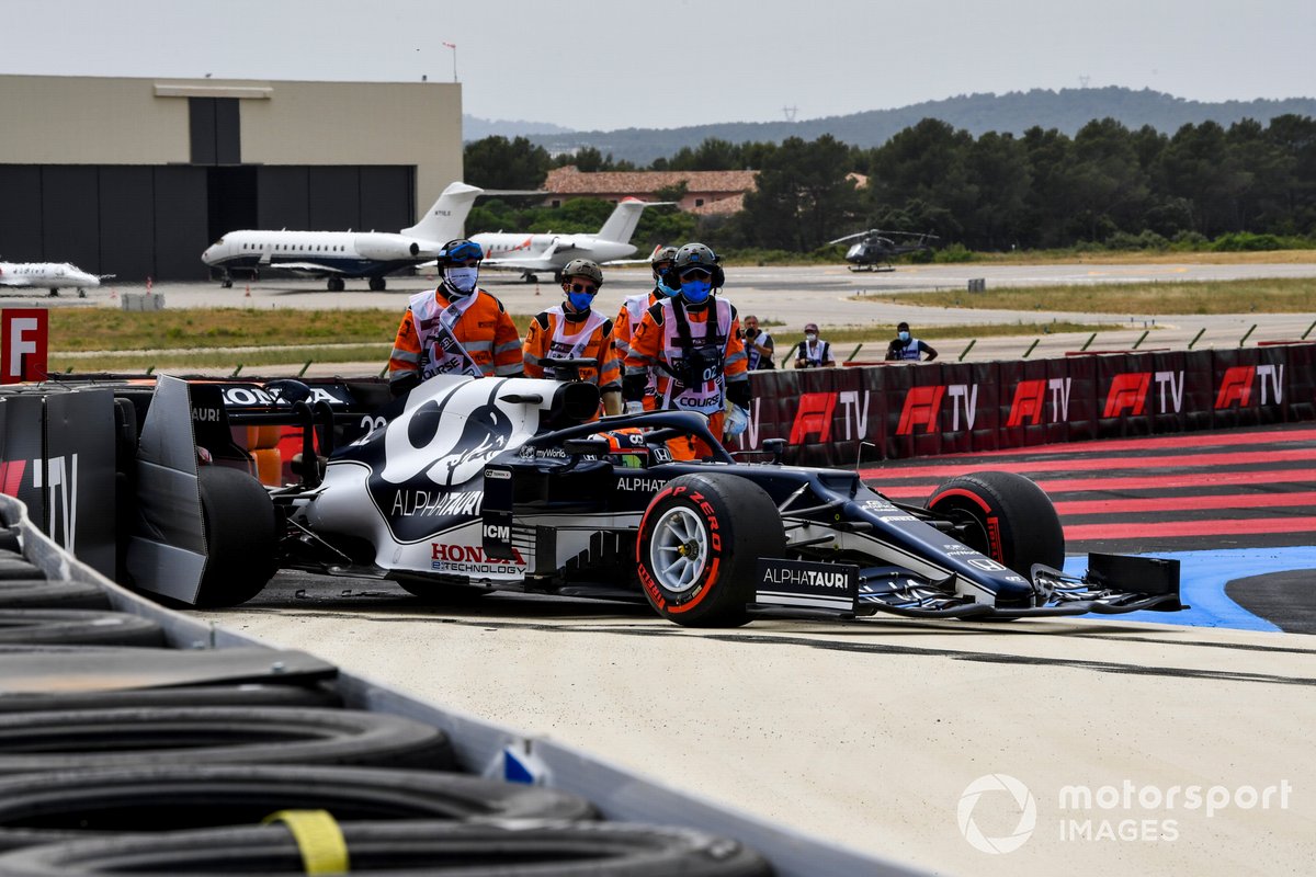 Los oficiales de pista asisten a Yuki Tsunoda, AlphaTauri AT02, después de chocar