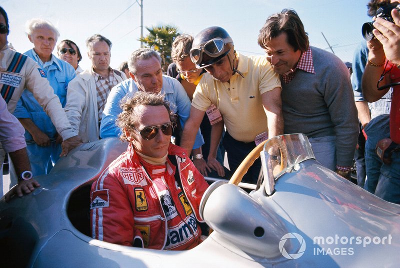 Niki Lauda takes a seat in a Mercedes Grand Prix car from 1954 with next to him Juan Manuel Fangio
