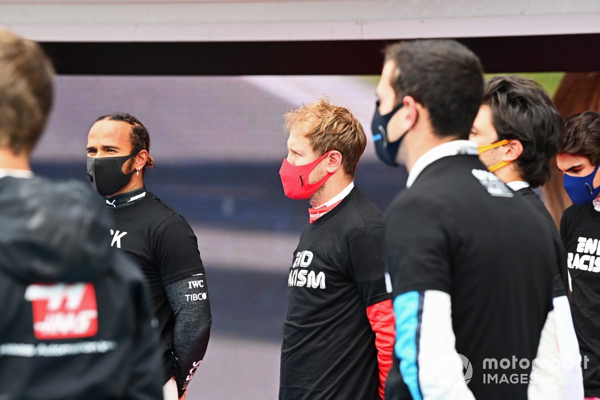 Los otros pilotos se reúnen alrededor de los trofeos antes del comienzo en apoyo de la campaña para el fin del racismo