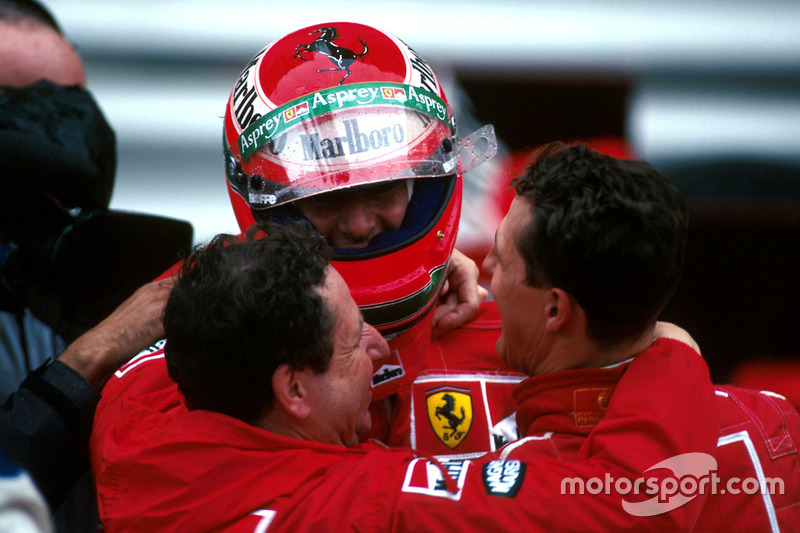 Race winner Michael Schumacher, Ferrari F310B and Jean Todt embrace Eddie Irvine, Ferrari F310B