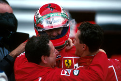 Il vincitore Michael Schumacher, Ferrari F310B e Jean Todt abbracciano Eddie Irvine, Ferrari F310B