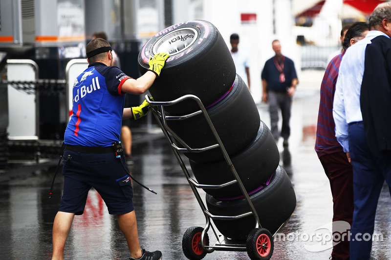 Un mécanicien Toro Rosso avec une pile de pneus